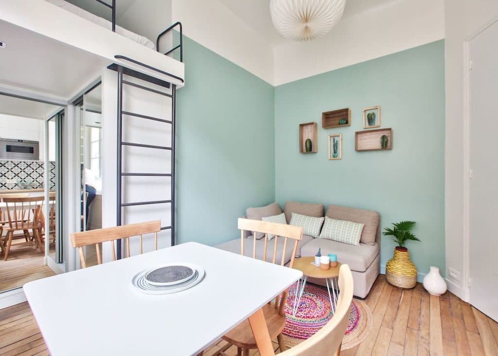 studio 18m2 parisien parquet bois salle à manger séjour ouvert canapé gris chaise table armoire dressing porte miroir peinture tapis rotin - blog déco - clem ATC