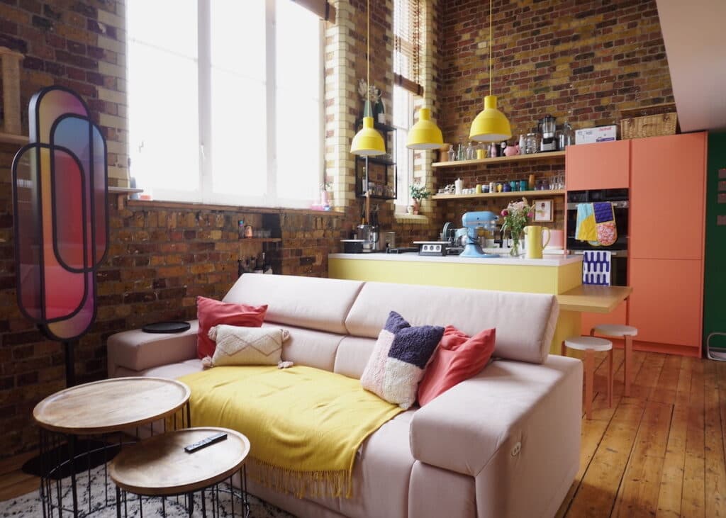 salon cuisine ouverte canape droit blanc mur brique