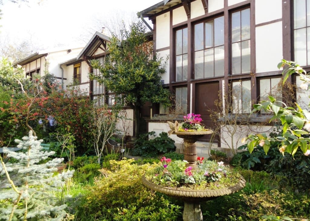 deco exterieure jardin fontaine fleurie plantes maison bois blanc