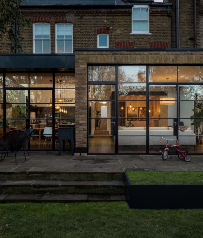 maison ouverte jardin terasse vue interieur baies vitrees briques exterieur canape salon cuisine jardin terasse