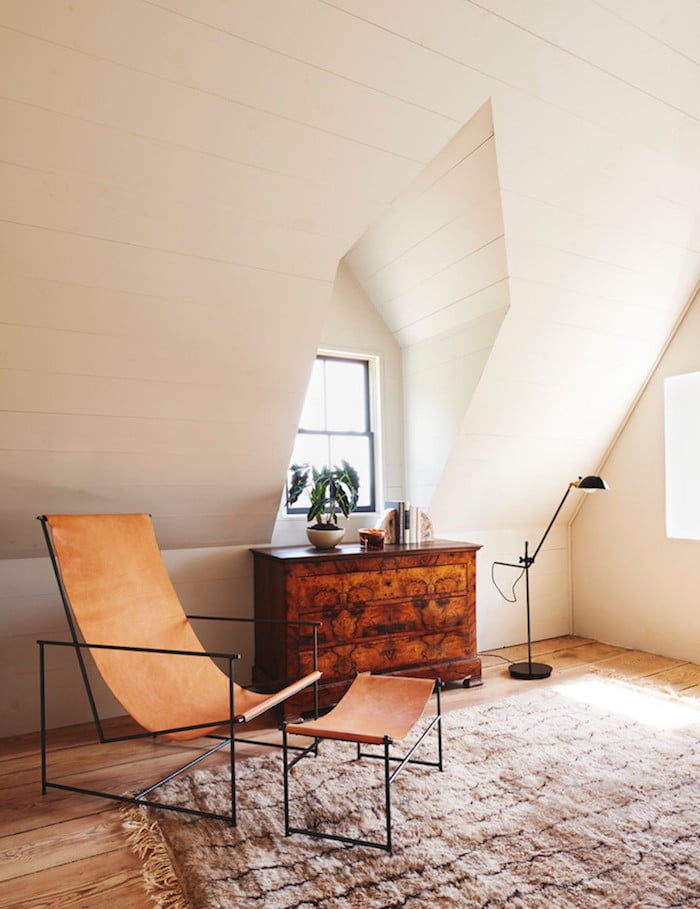 ancienne ferme rénovée coin lecture fauteuil cuir minimaliste