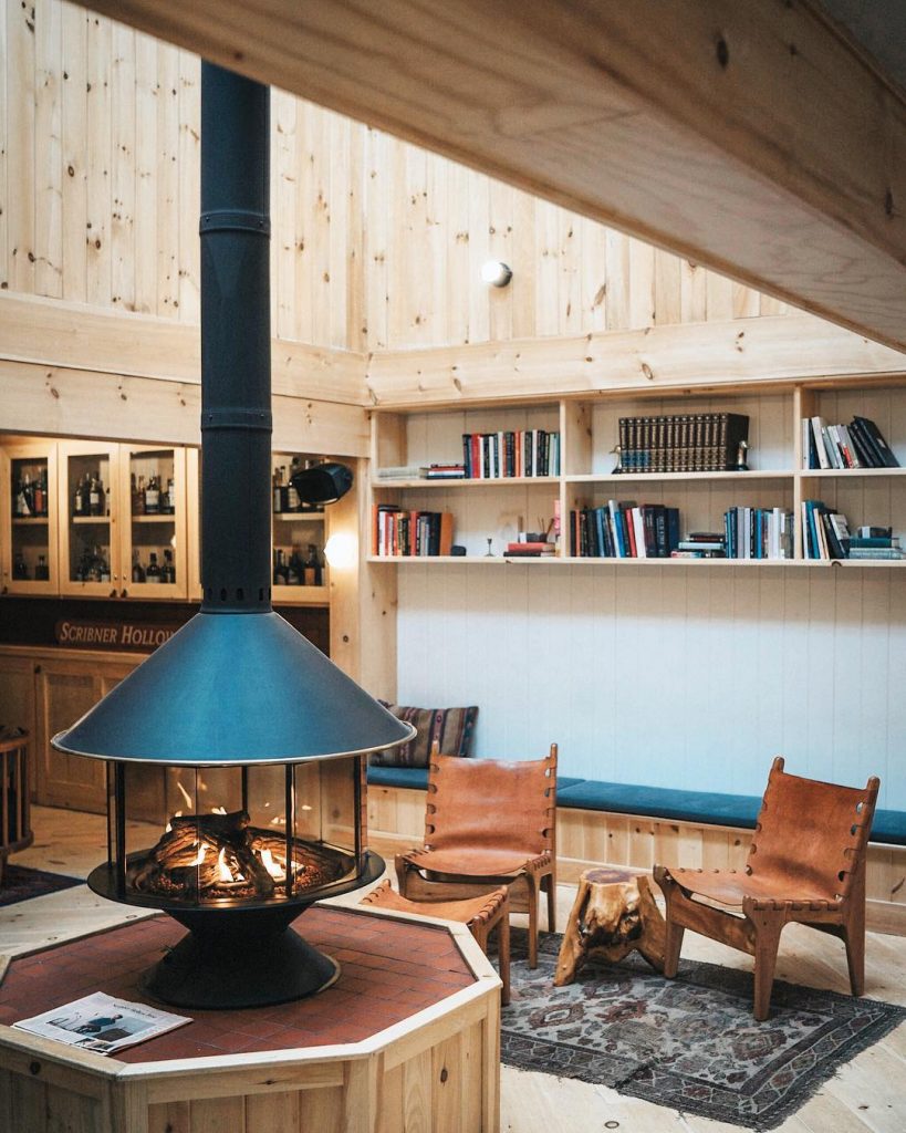 chalet noir poêle noir banquette coussin bleu tapis gris - blog déco - clem around the corner