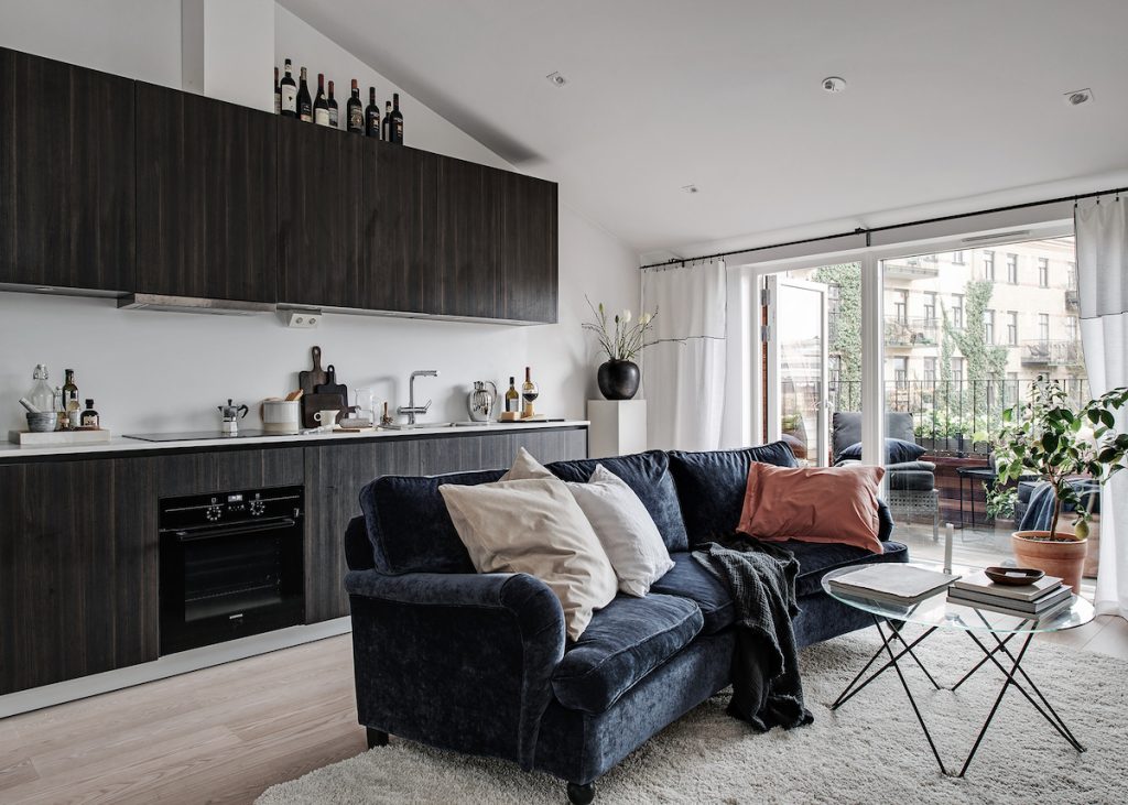 idée déco studio salon cuisine ouverte canapé velours bleu marine coussin beige saumon - blog déco - clem around the corner