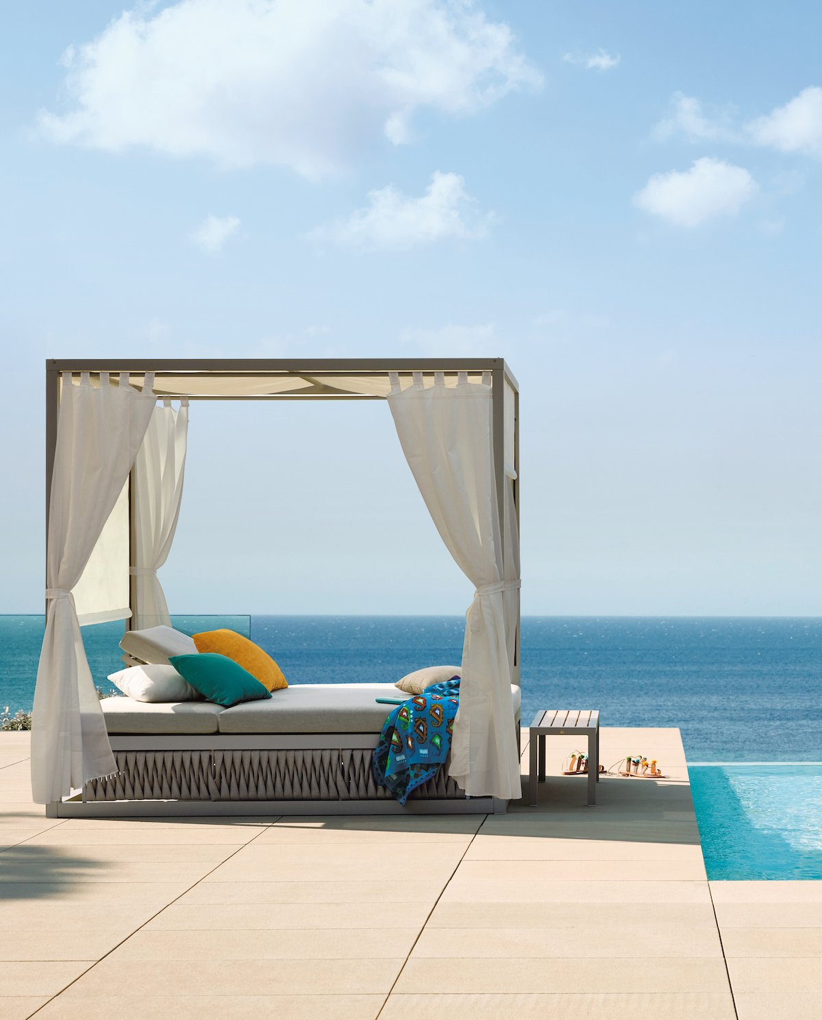 terrasse piscine débordement lit baldaquin vue sur mer ciel bleu vacance