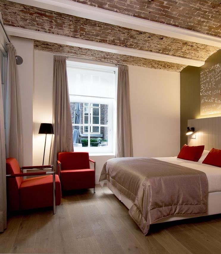 hôtel prison chambre rustique taupe plafond briques rouges clemaroundhtecorner