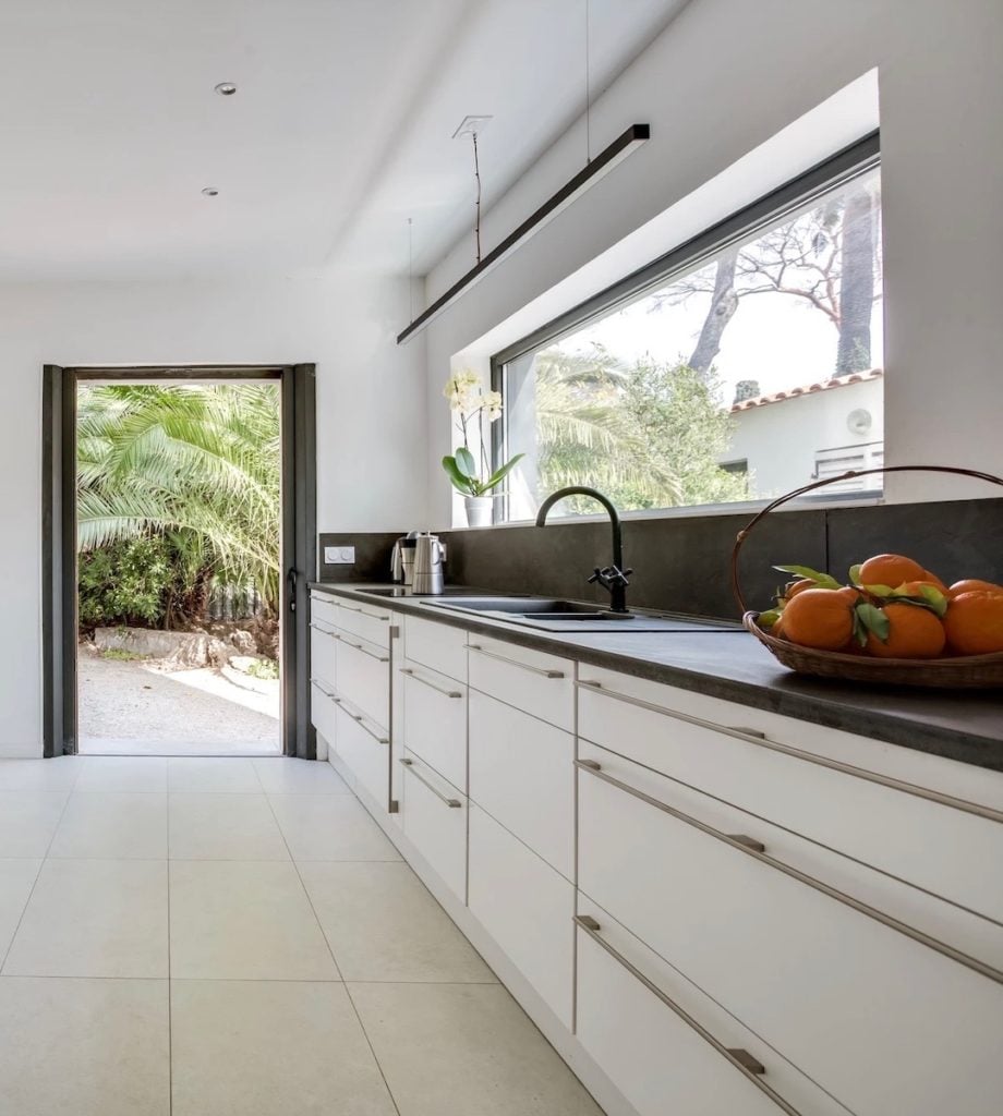 cuisine fermée meuble blanc robinet noir ouverture extérieure plan de travail noir clematc