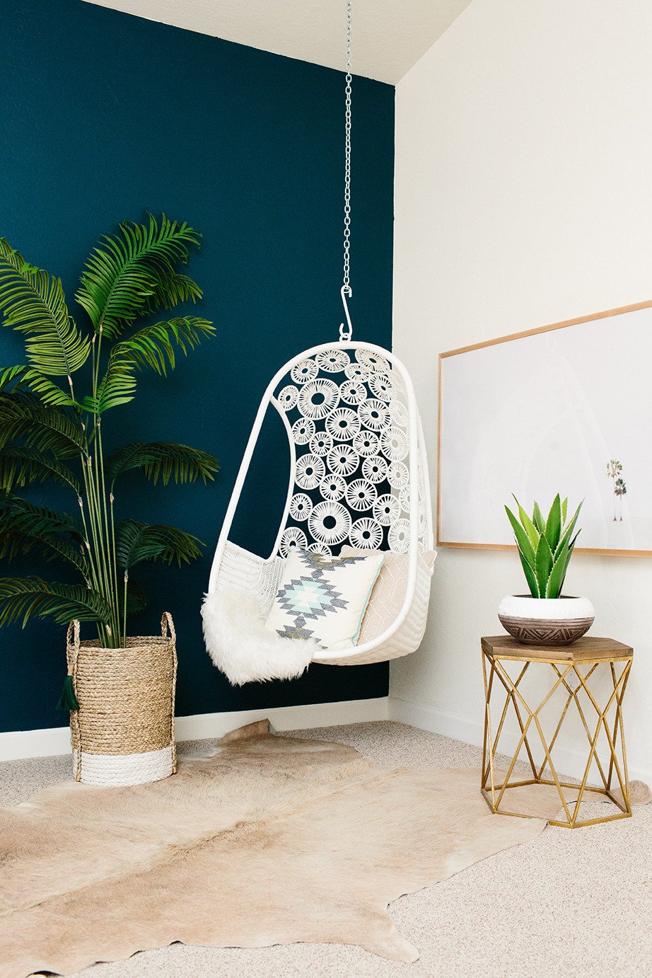 salon bohémien fauteuil en suspension plante verte mur bleu clematc