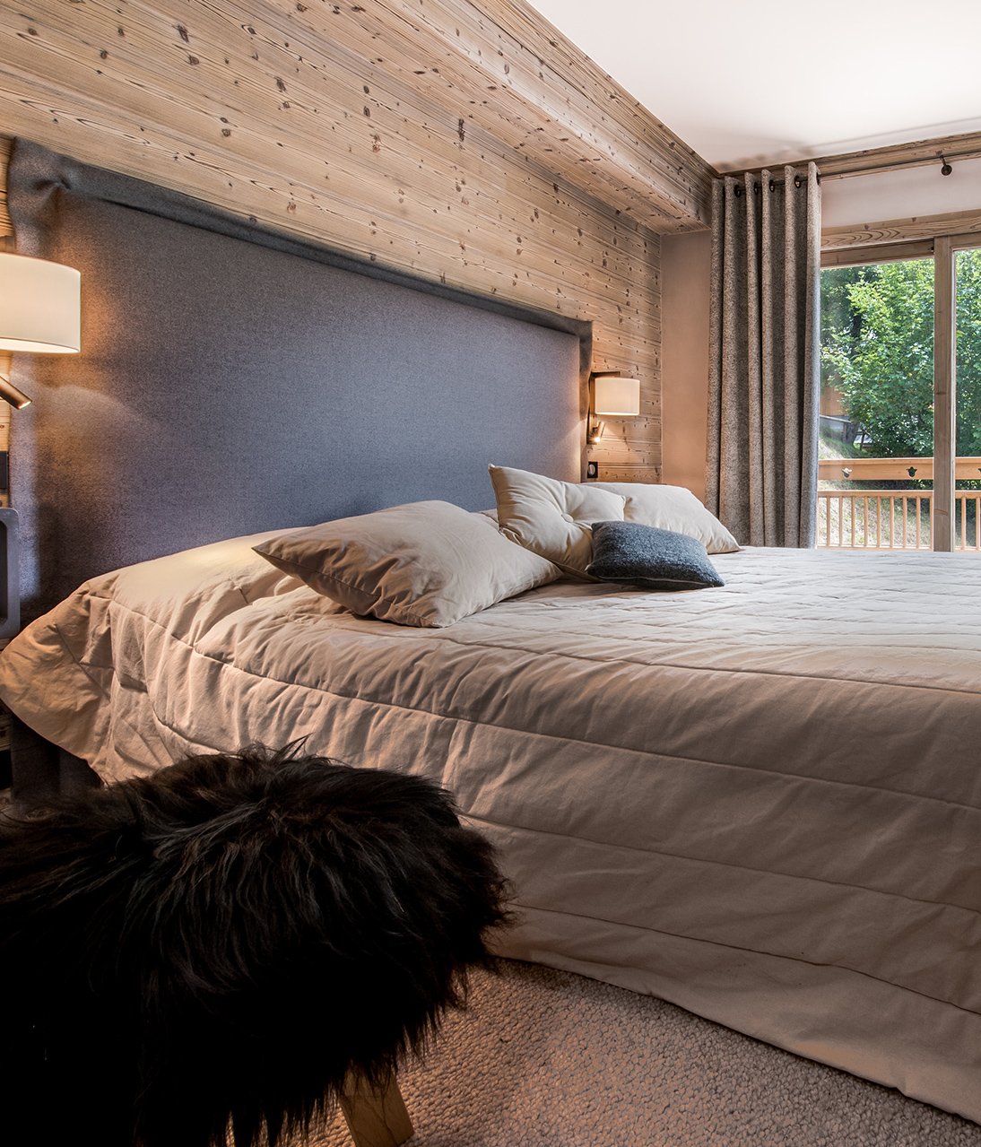 Chambre parentale style chalet montagnard gris moquette tabouret bois fourrure noire