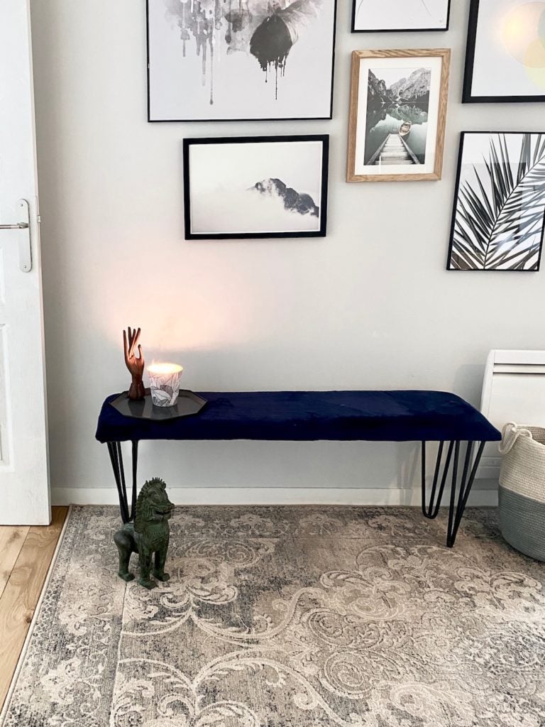 mur de cadres tapis moldave en laine vintage gris aménagement banc velours bleu petite entrée