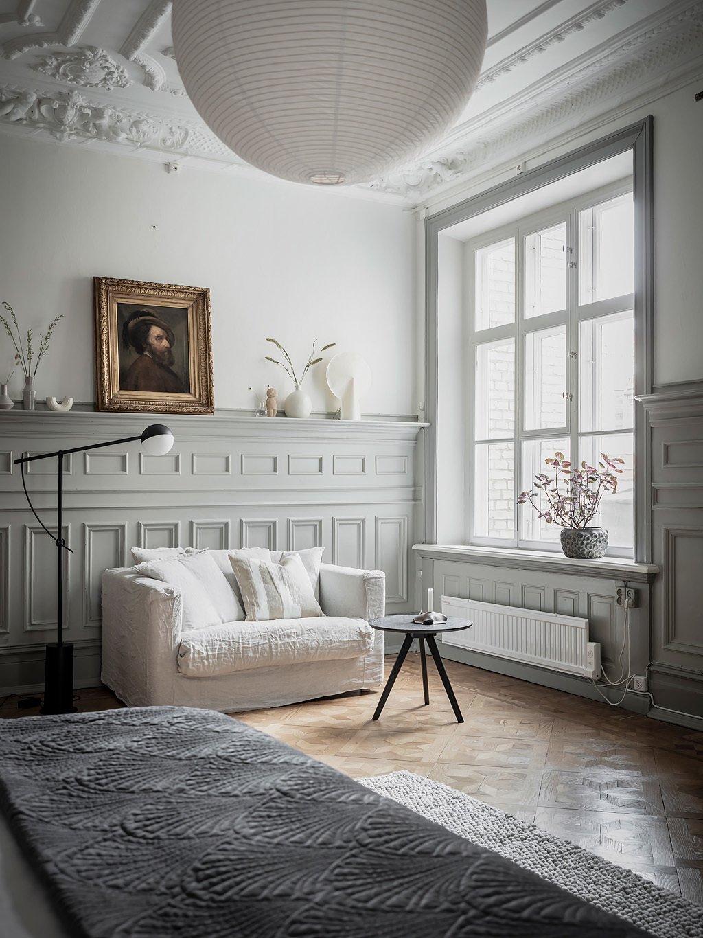 chambre coin détente canapé blanc deux places table basse ronde espace lumineux lampe design