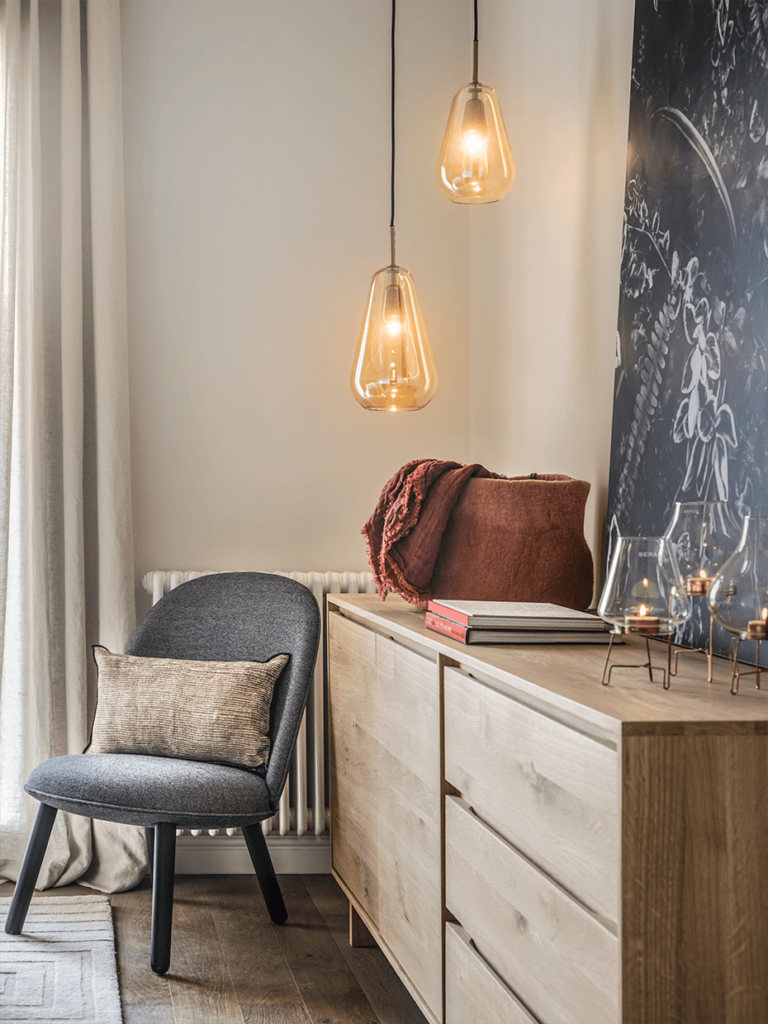 appartement Eixample chambre parentale fauteuil gris buffet bois élégant sobre