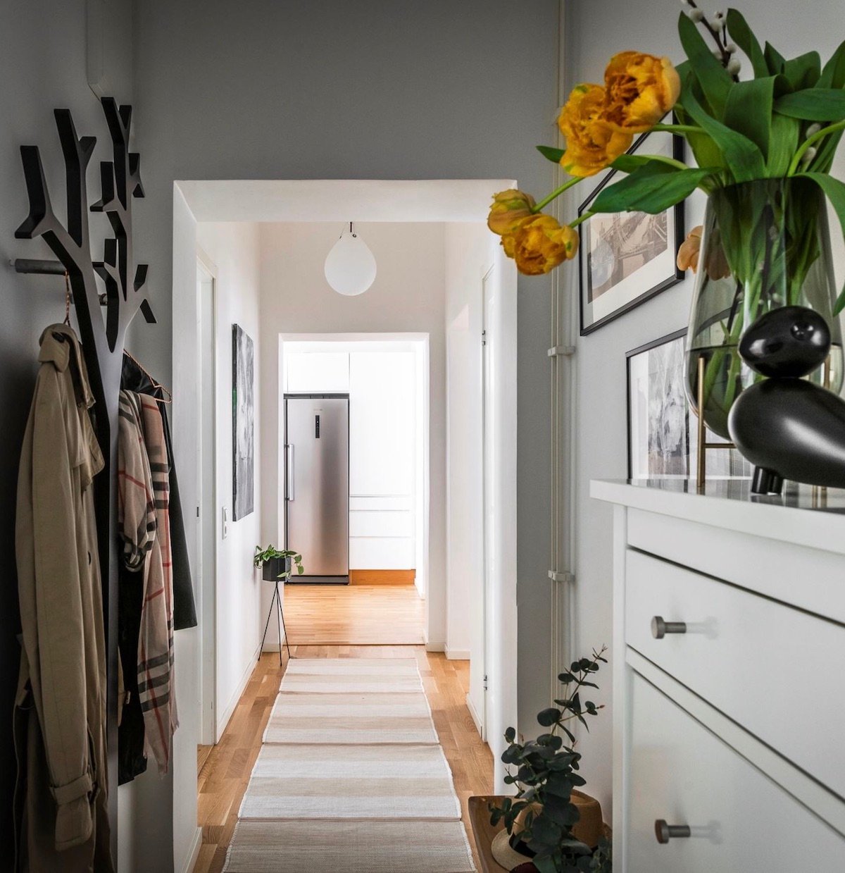 appartement Linné Goteborg aménagement couloir entrée porte-manteau arbre noir
