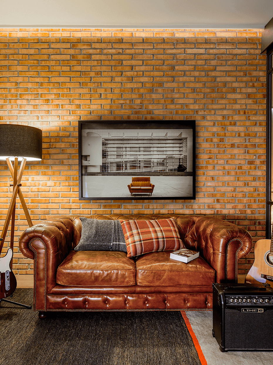 comment aménager garçonnière mur briques canapé rétro anglais chesterfield cuir cognac