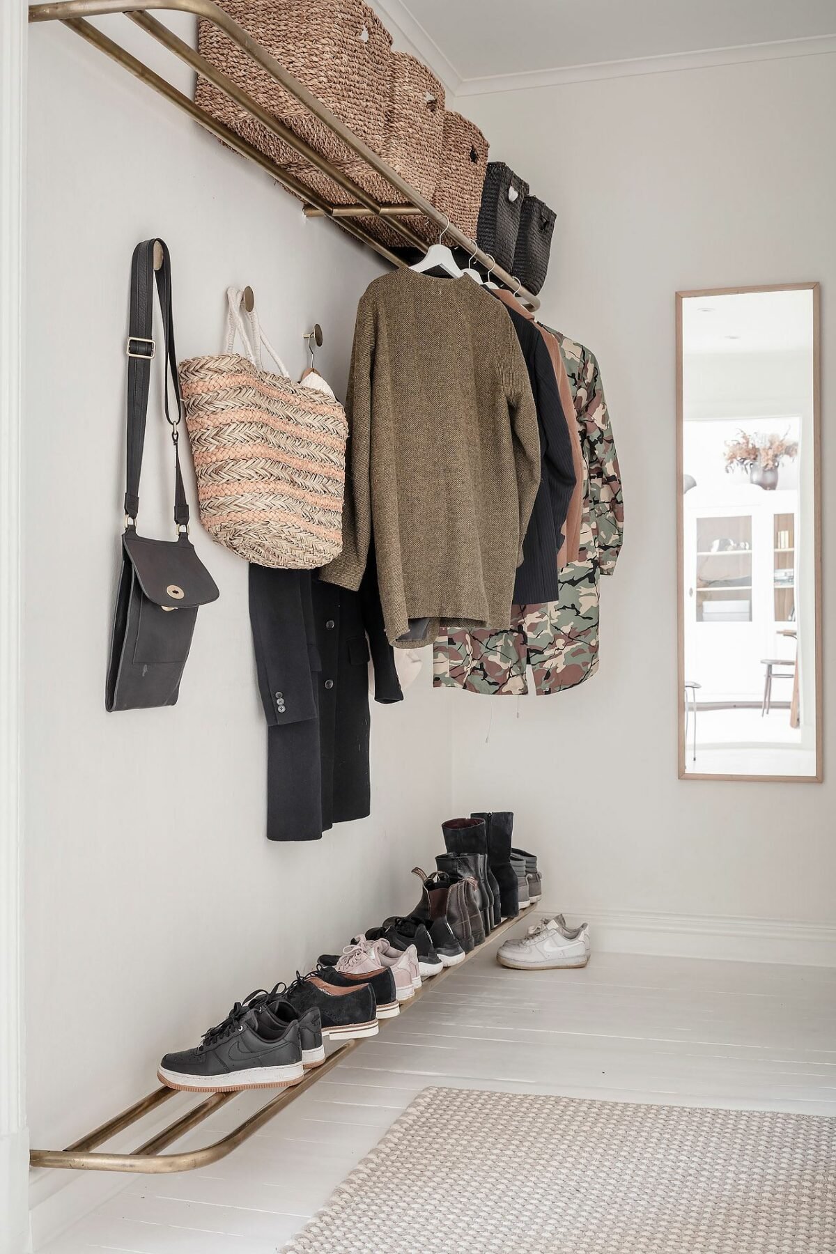 entrée salon blanc rangement mural métal doré minimaliste