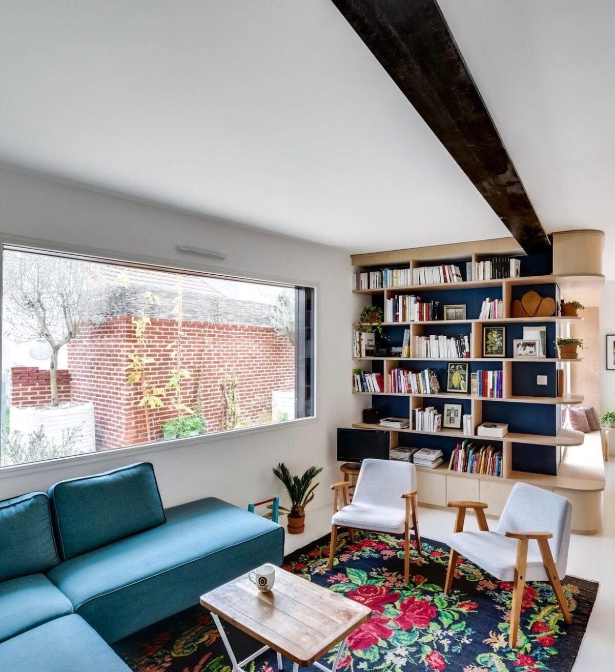 salon canapé angle bleu turquoise tapis motif fleur rouge vert noir