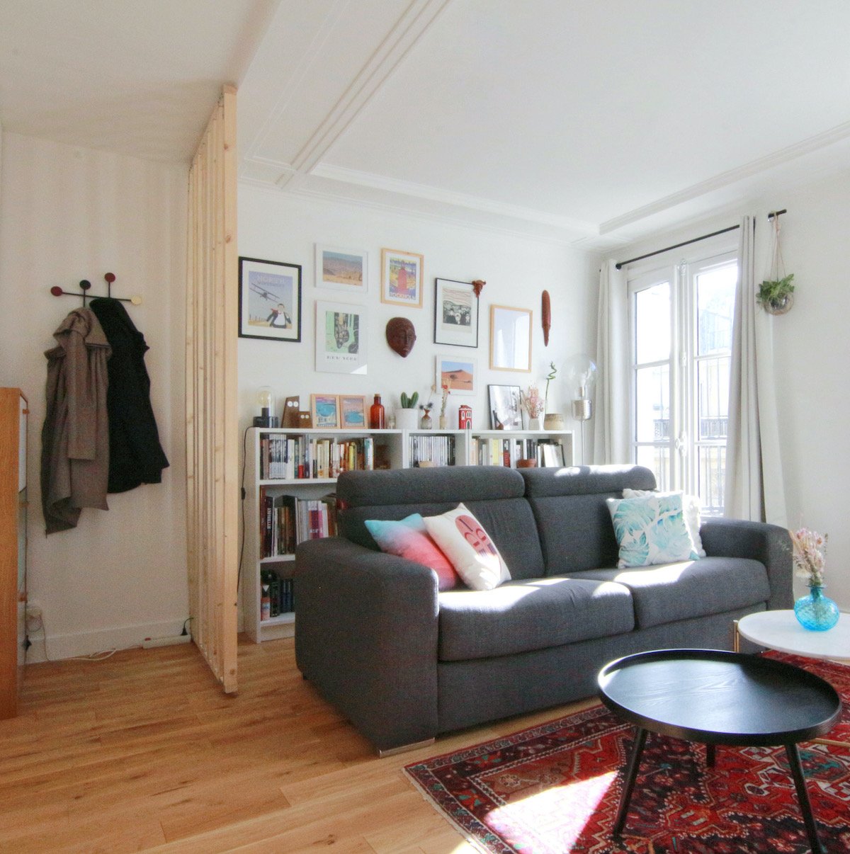 entrée cloison claustra bois salon canapé gris tapis ethnique rouge