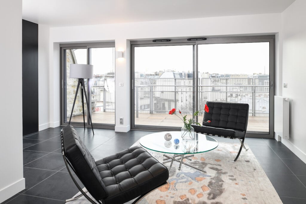 salon moderne blanc noir carrelage fauteuil Barcelona chauffeuse cuir