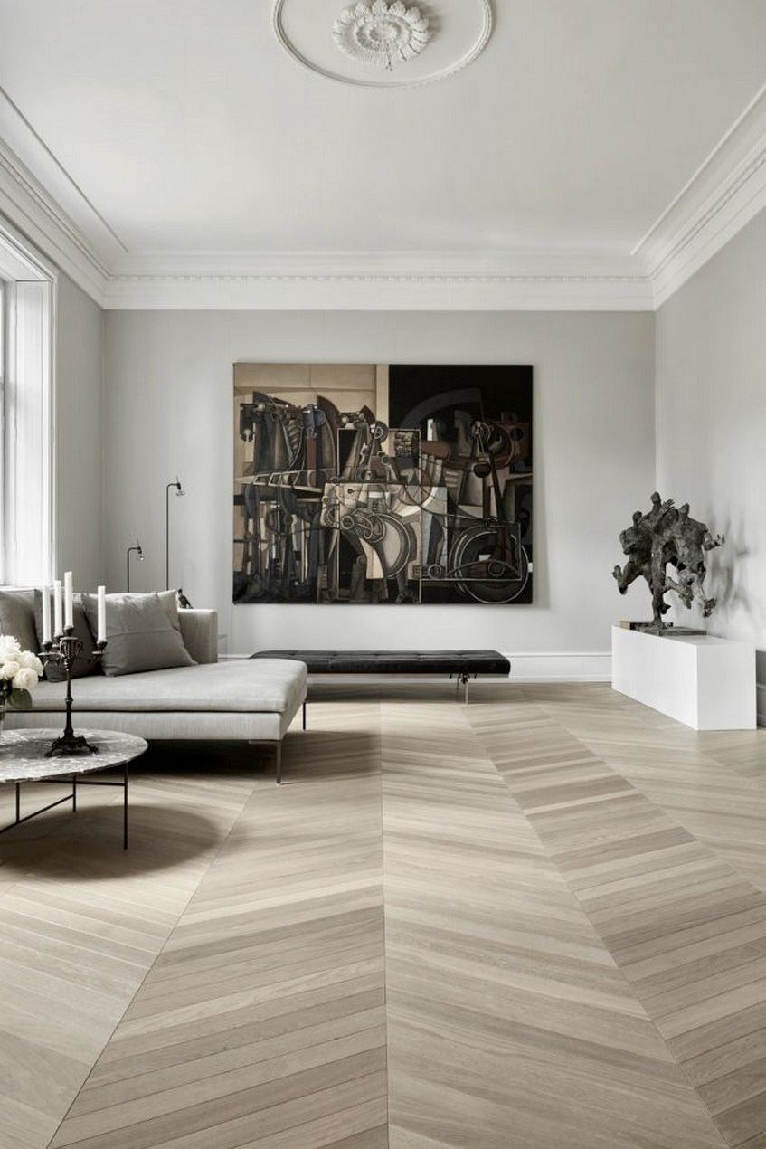 salon spacieux sophistiqué parquet chevron moulures murs table basse ronde marbre