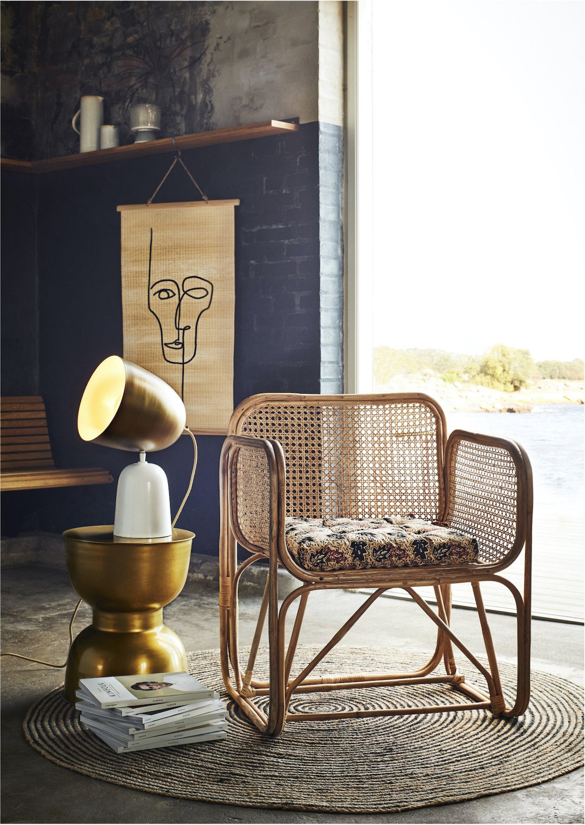 fauteuil en cannage mur en brique noir tapis rond rotin