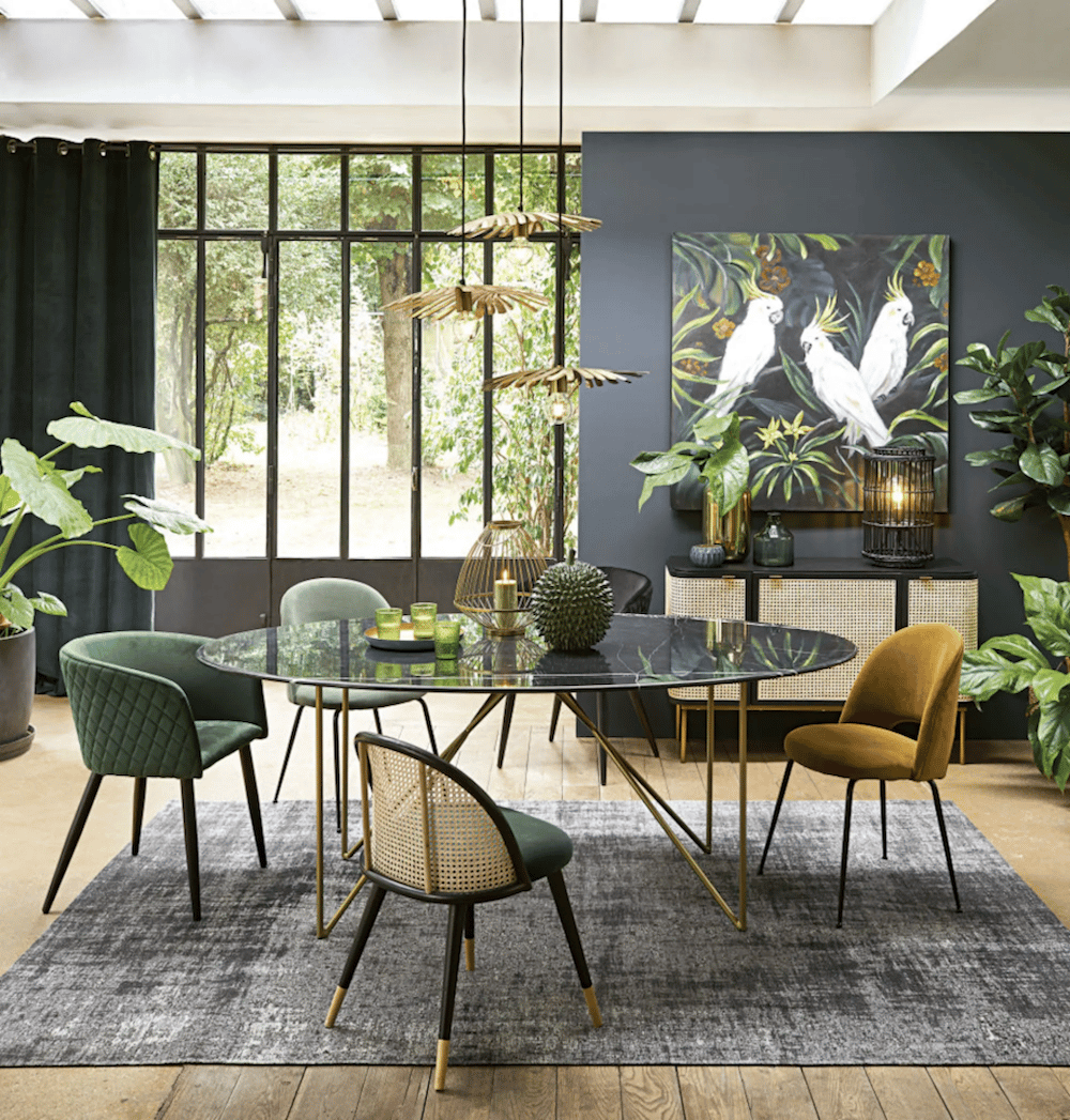 salle à manger urban jungle table ronde suspension en laiton chaises dépareillées tapis gris