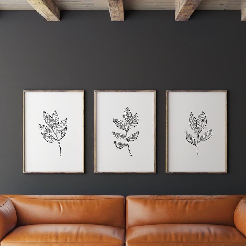 salon canapé droit cuir marron mur noir tableau noir et blanc