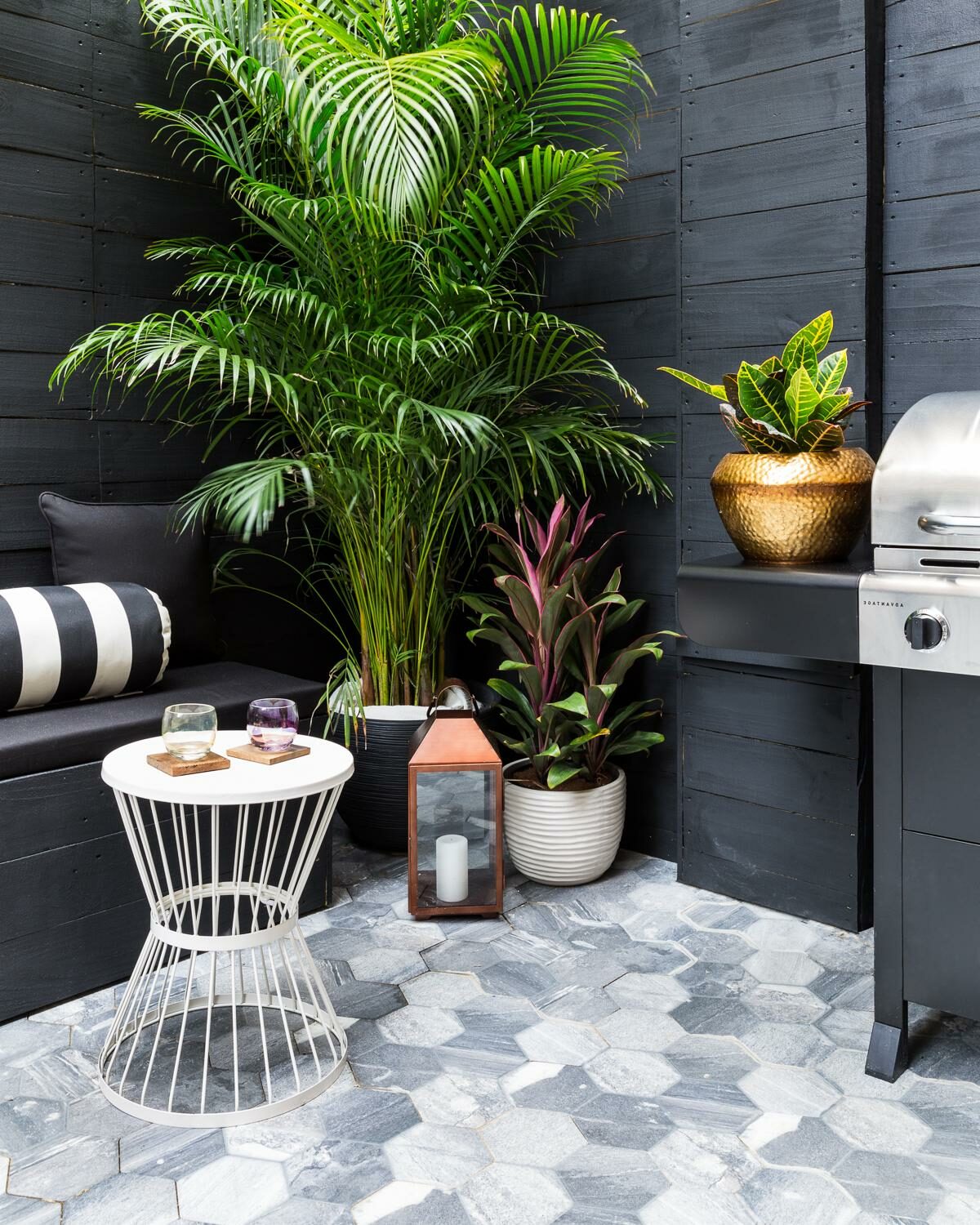 terrasse noire mur bois plante verte table basse ronde blanche