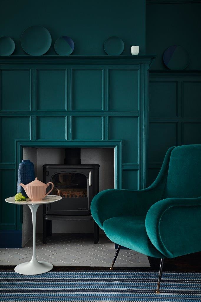 coin salon vert fauteuil arrondi tapis rayés table basse ronde blanche