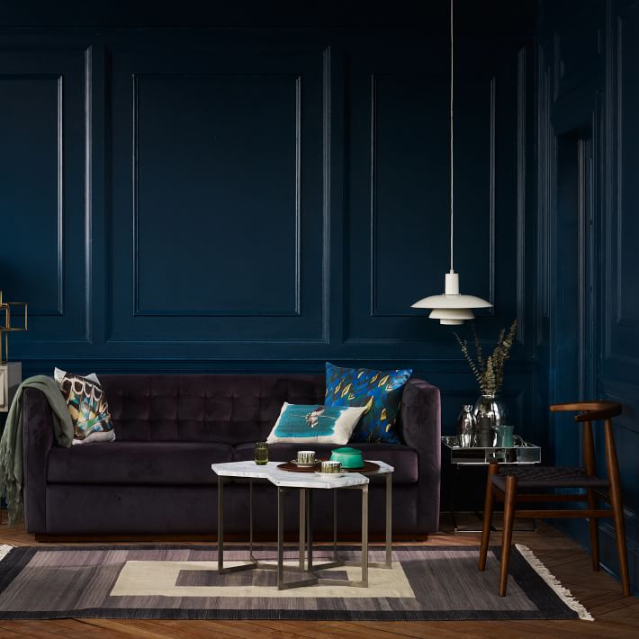 intérieur sombre mur bleu canapé droit gris tapis géométrique