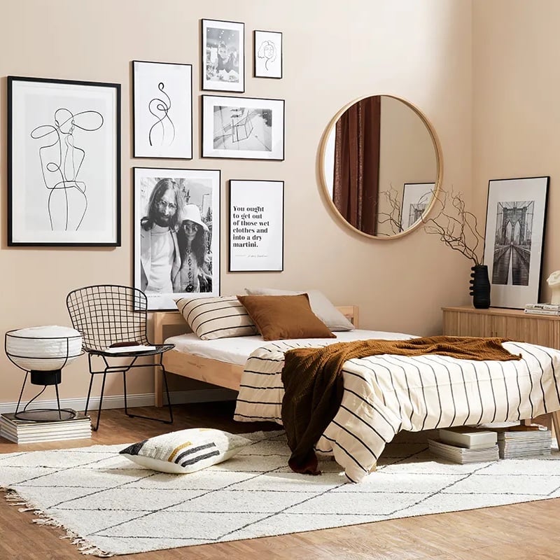 chambre beige lumineuse mur de cadres abstraits noir et blanc