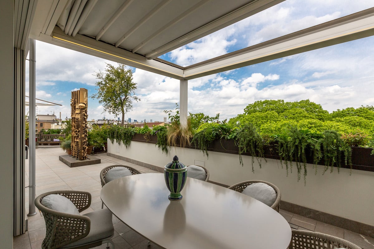 Aménagement extérieur Installation d’une pergola adossée reposant sur le muret. L’écoulement de l’eau dans les poteaux permet d’arroser naturellement la haie de plantes vertes