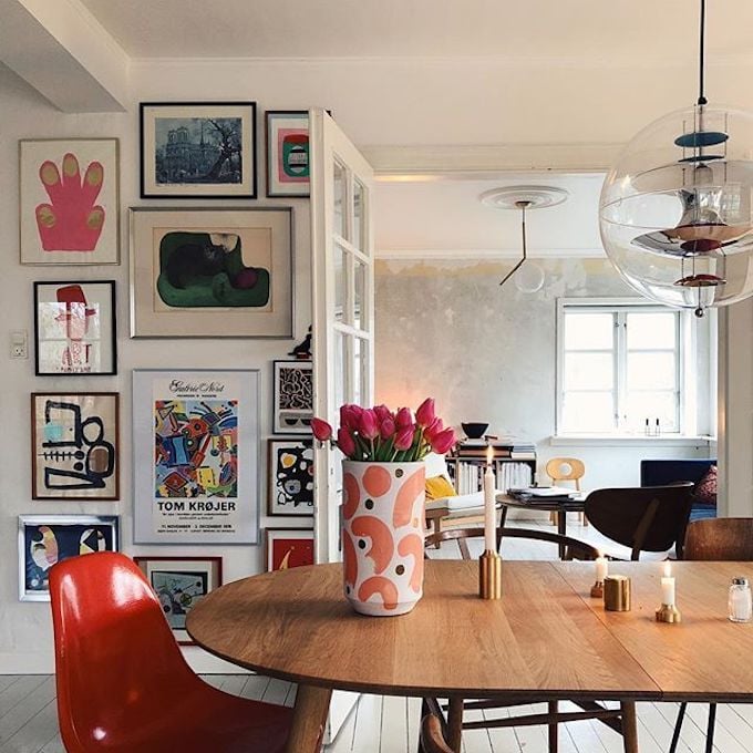 salle à manger ouverte table bois mur de cadre chaise rouge suspension verre soufflée