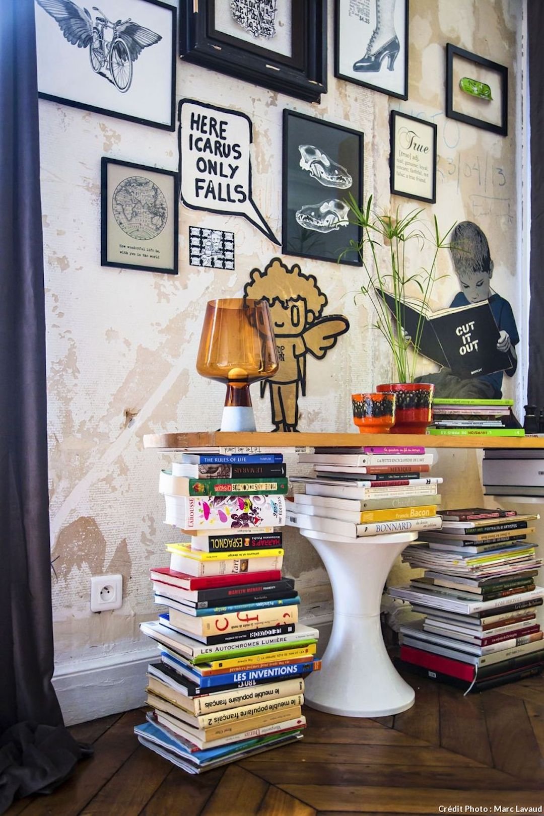 salon couloir deco ARTY galerie d'art livres planche bois tabouret oval blanc mur de cadre noir