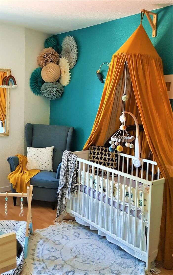 chambre bebe berceau blanc mur bleu canard voile orange tapis rond canapé gris