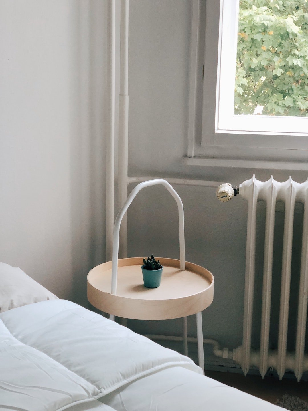 chambre épurée lumineuse table de chevet drap blanc radiateur