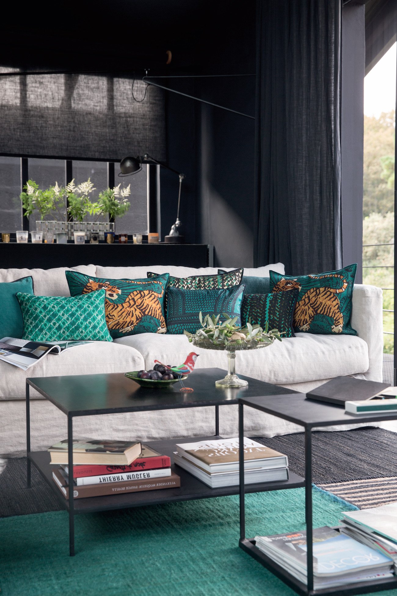 salon mur noir canapé bleu turquoise coussin tigre table basse métal carré cube