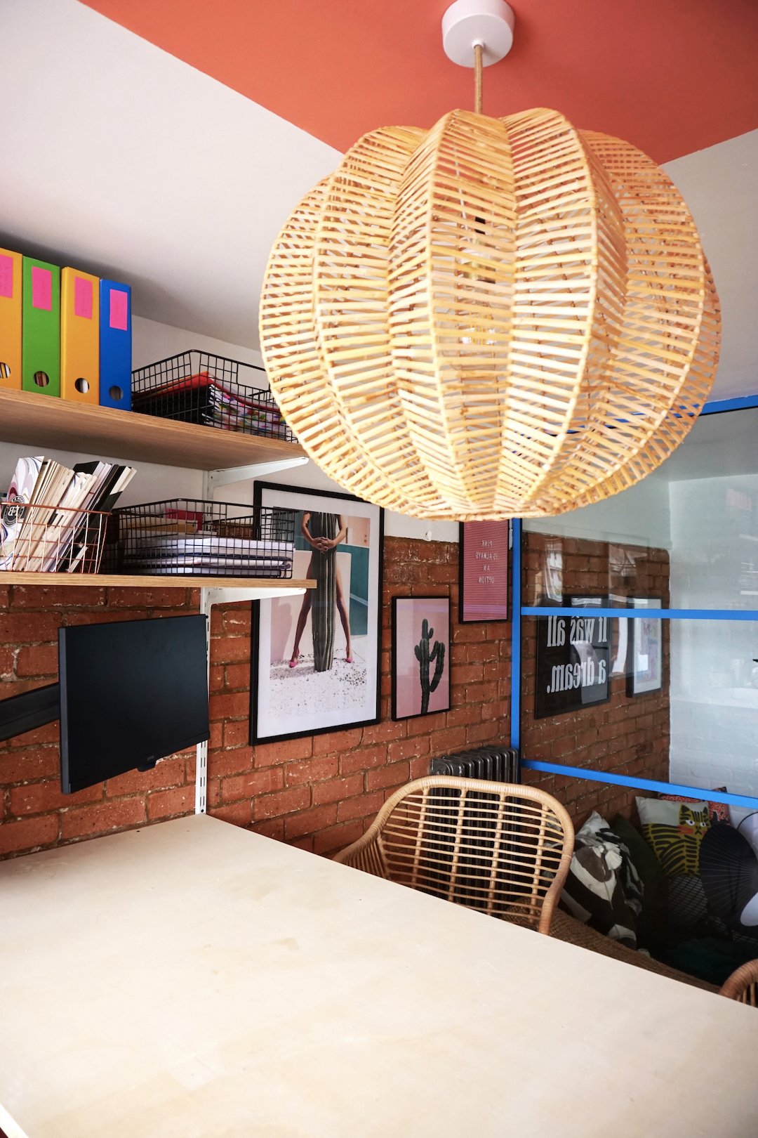 bureau table blanche chaise suspension rotin mur brique rouge