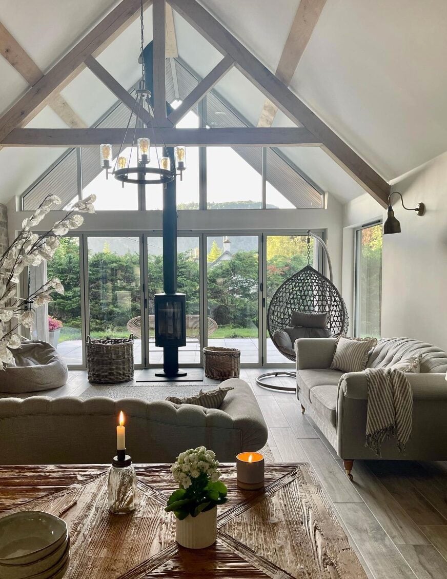 salon lumieux porte vitree poutre bois apparent canape gris piece de vie