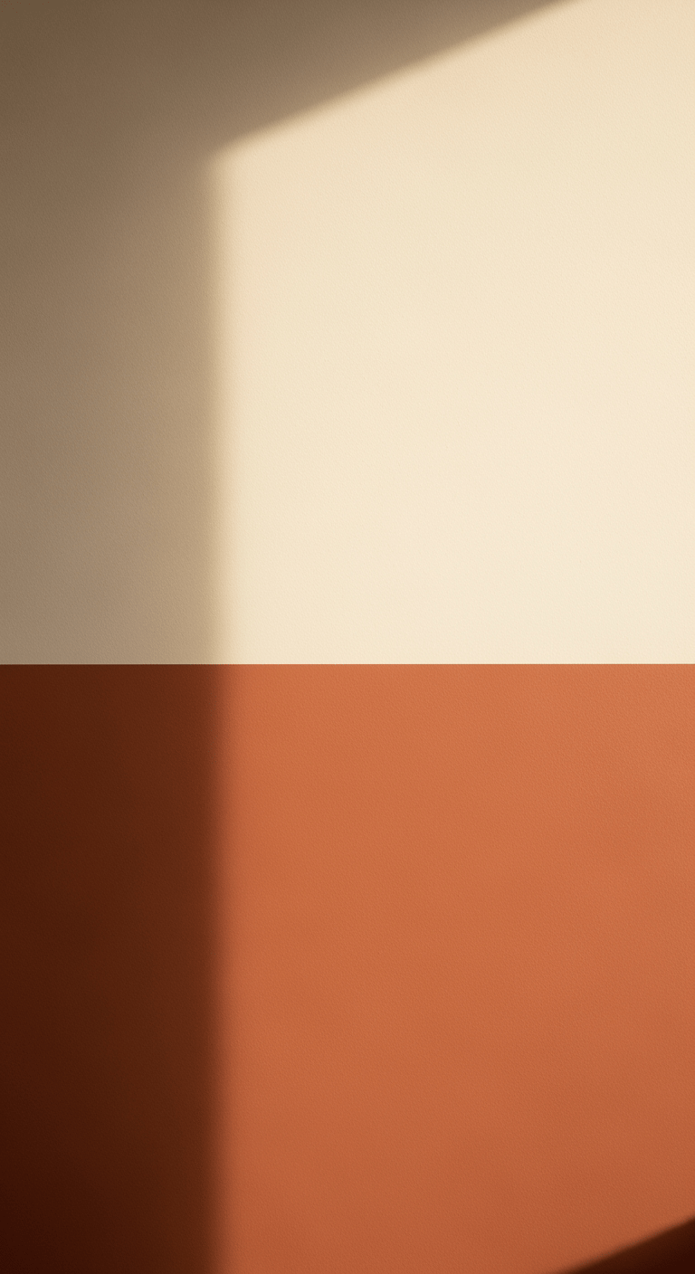 Vue d'un mur peint avec un soubassement de couleur terre cuite et la partie supérieure en blanc crème, une technique pour élargir visuellement l'espace.