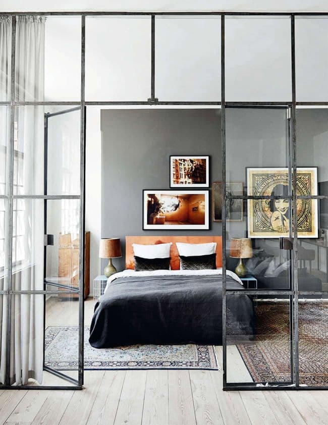 dans un loft, les espaces sont séparés avec de grandes verrières d'atelier et la couleur est amenée par un tapis persan
