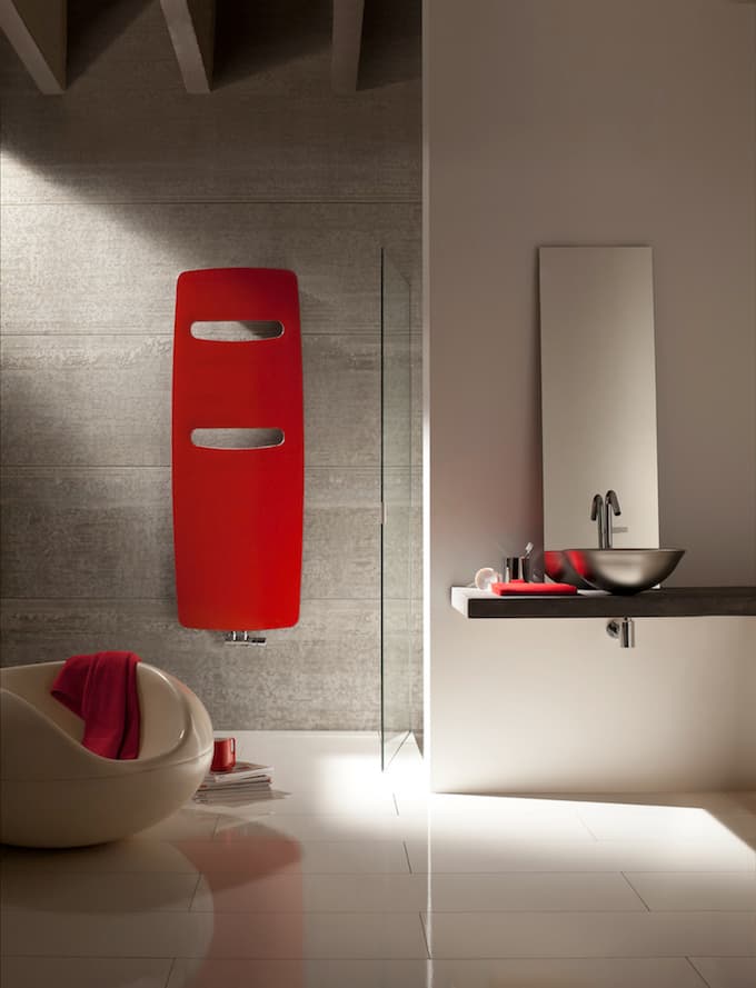 Radiateur sèche-serviettes rouge dans une salle de bain grise contemporaine