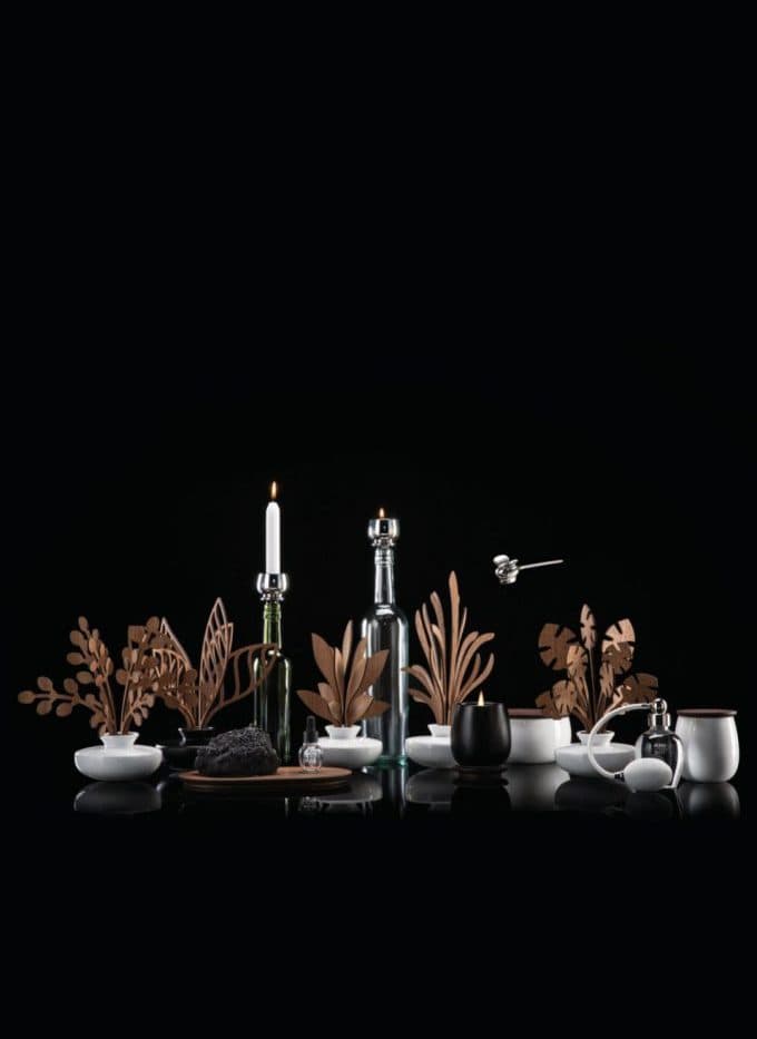 Bougie Alessi The Five Seasons posée sur une table avec une feuille de monstera