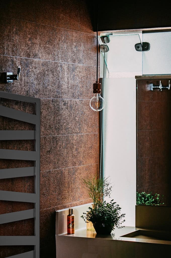 Radiateur sèche-serviettes Kazeane brun dans une salle de bain décorée de plantes