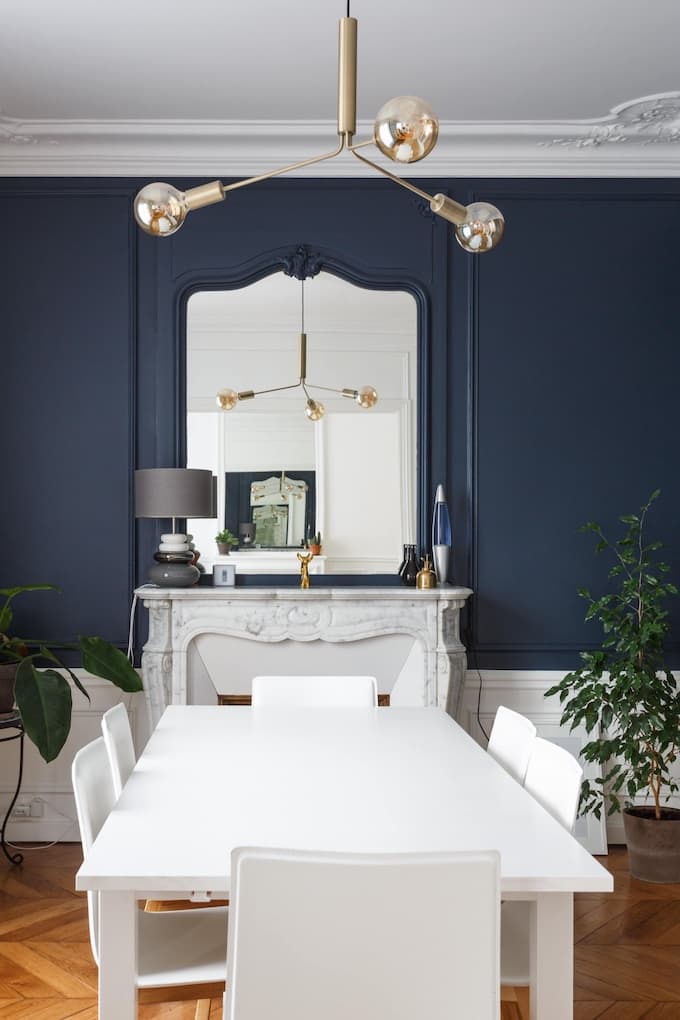 appartement chic parisien salle à manger soubassement blanc moulure suspension abat-jour verre rond mur bleu table parquet bois - blog déco - clemaroundthecorner