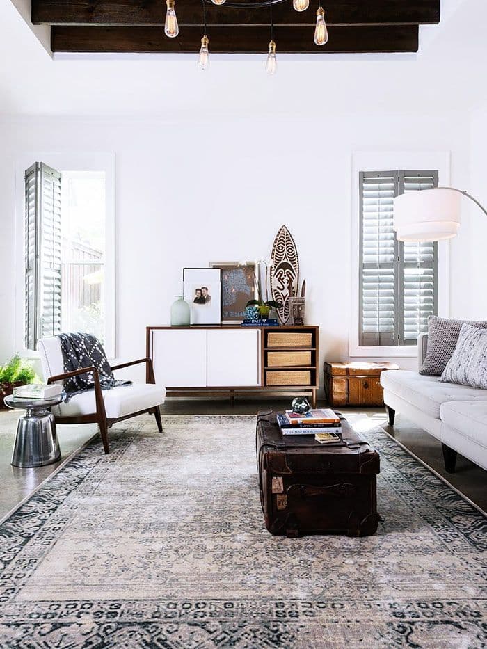 salon style colonial avec fauteuil scndinave vintage et tapis persan