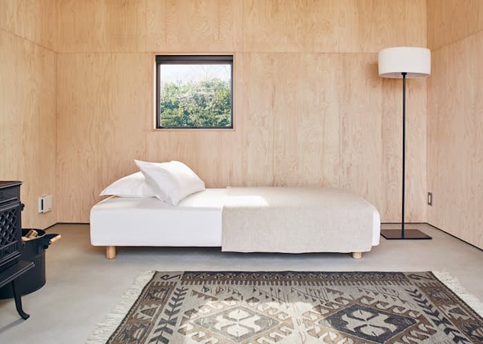 cabane muji interieur bois tapis lit lampe fenetre