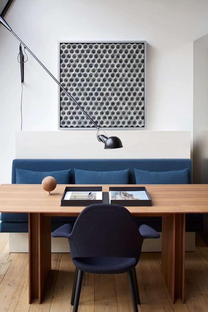 appart parisien toit canape table salle a manger table en bois brut design tableau original noir et blanc assise bleu avec coussin lampe metalique paris appartement