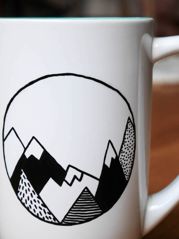 dessin de montagnes sur un mug en porcelaine avec un feutre noir