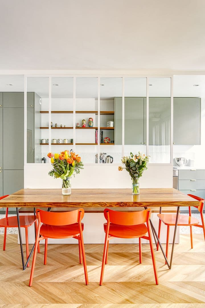 salle à manger table bois chaise orange fluo verrière blanche