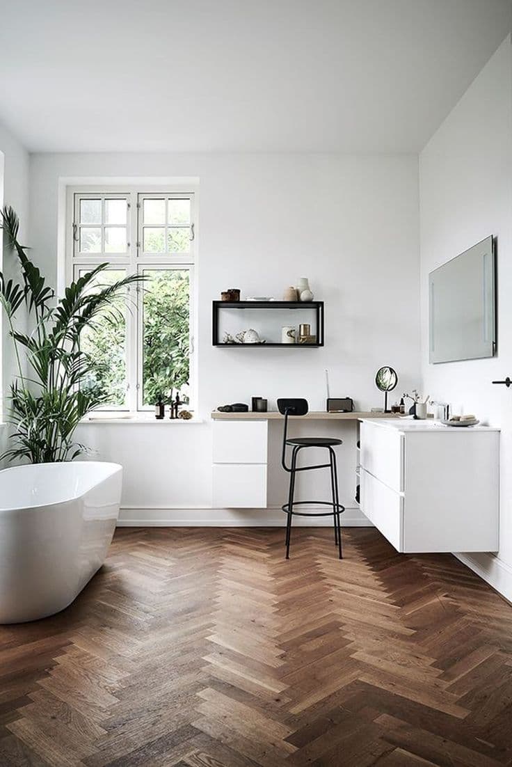 salle de bain lumineuse décoration chevron bois foncé baignoire ovale plante verte