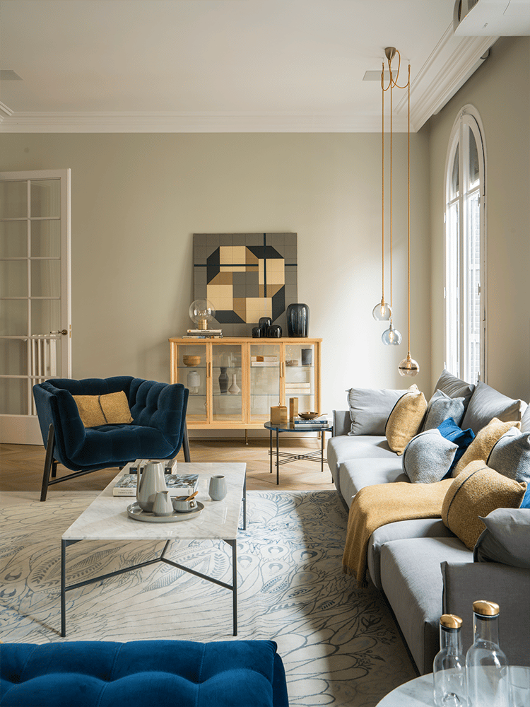salon cosy gris canapé tapis motif plume paon fauteuil velours bleu foncé